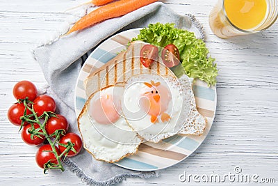 Funny toast with fried eggs in a shape of chicken, healthy food for kids Easter idea, top view Stock Photo