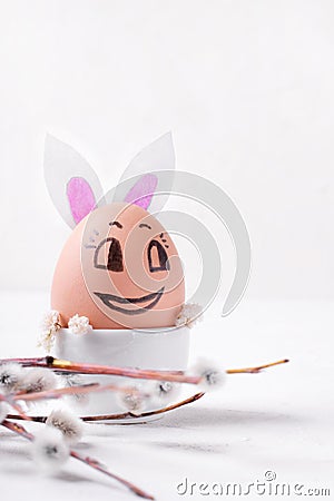 Funny Easter egg reminding cute bunny and willow twig Stock Photo