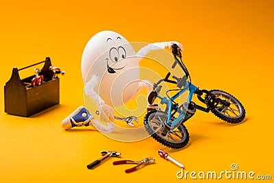Funny egg repairing bike with tools Stock Photo