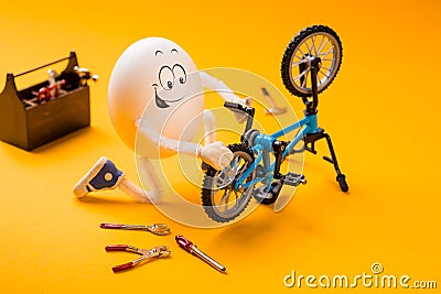 Funny egg repairing bike with various tools Stock Photo