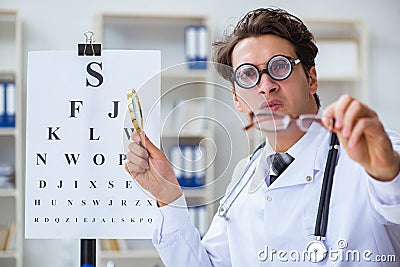 The funny eye doctor in humourous medical concept Stock Photo