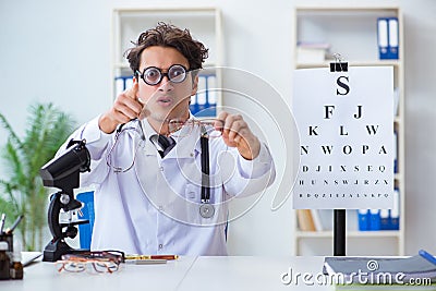 The funny eye doctor in humourous medical concept Stock Photo