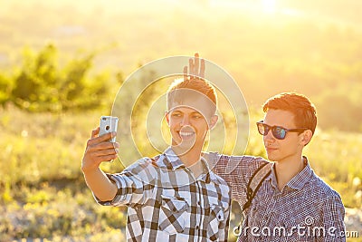 Funny friends guys are photographed on phone selfie on a Sunny day Stock Photo