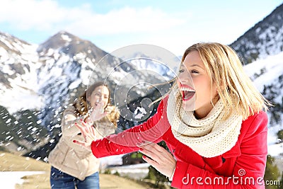 Funny friends joking throwing snowballs Stock Photo