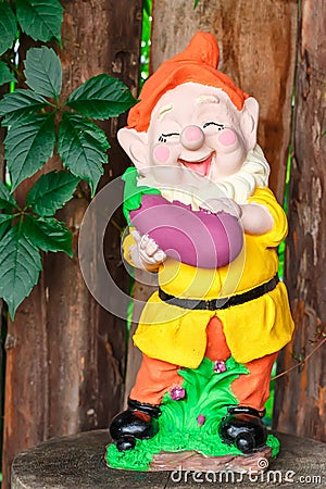 Funny garden dwarf with eggplant Stock Photo