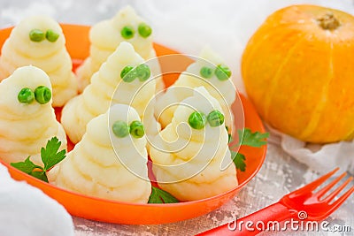 Funny ghosts from mashed potatoes and green peas, creative dinner dish for Halloween Stock Photo