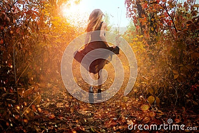 Funny girl in black dress running in golden autum forest Stock Photo
