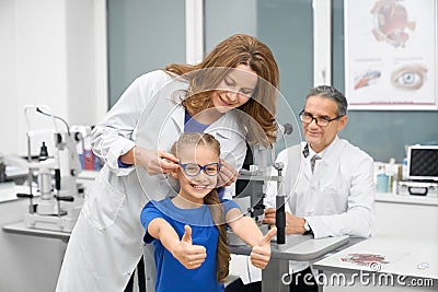 Funny girl choosing new glasses in optical shop Stock Photo