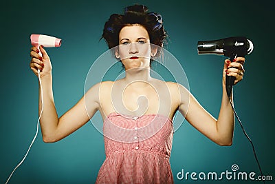 Funny girl in curlers with hairdryer styling hair Stock Photo