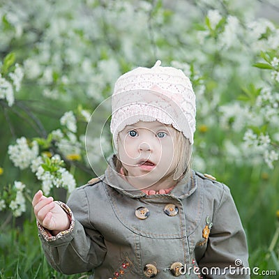 Funny girl with Down syndrome in the mouth pulls dandelions Stock Photo