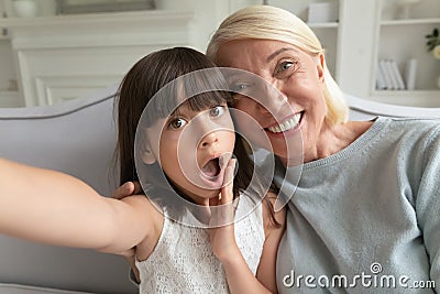 Grandmother and granddaughter holding camera taking self-portrait webcam view Stock Photo