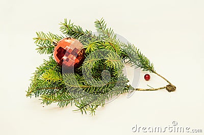 A funny handmade hedgehog from fir tree branches carrying a red ball for Christmas. Stock Photo