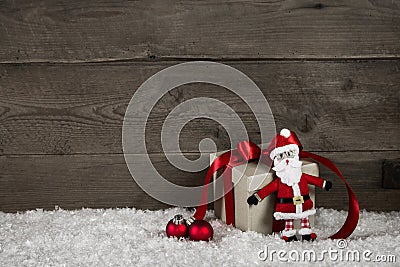 Funny handmade santa with a red christmas present on wooden back Stock Photo