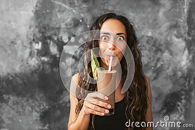 Funny happy woman drinking chocolate milk shake with cocoa and laughing Stock Photo