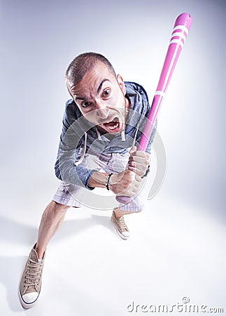 Funny hooligan with a pink baseball bat screaming in the studio Stock Photo