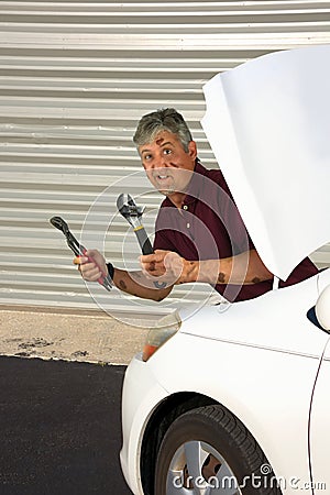 Funny humorous mechanic covered in grease with confused look on his face Stock Photo