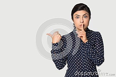 Funny Indian girl pointing finger at copy space, secret information Stock Photo