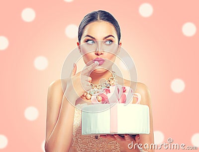 Funny joyful beauty model girl holding big beautiful party or birthday cake over pink background Stock Photo