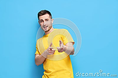 Funny joyful man pointing at you and looking to camera on blue background Stock Photo