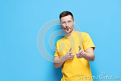 Funny joyful man pointing at you and looking to camera on blue background Stock Photo