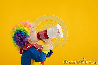 Funny kid clown playing against yellow background Stock Photo