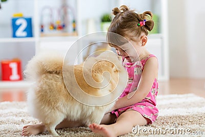 Funny kid with dog Spitz at home Stock Photo