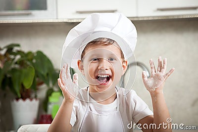 Funny baby with flour, happy emotional boy smiles happily Stock Photo