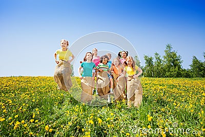 Funny kids jumping in sacks playing together Stock Photo