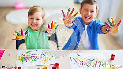 Funny kids show their palms the painted paint. creative classes fine arts. two children a boy and a girl laugh. selective focusing Stock Photo