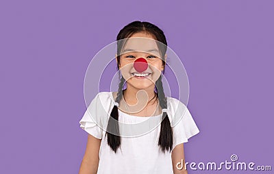 Funny Korean Kid Girl Posing Wearing Clown`s Nose, Studio Shot Stock Photo