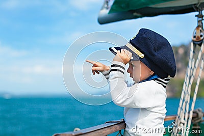 Funny little baby captain on board of sailing yacht Stock Photo