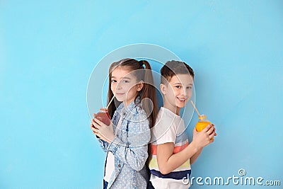 Funny little children drinking citrus juice on color background Stock Photo