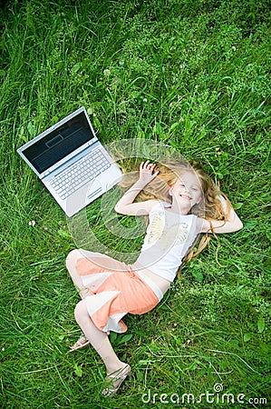 Funny little girl with laptop outside Stock Photo