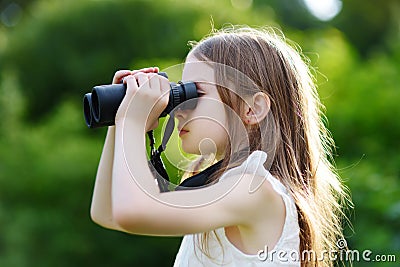 Funny little girl looking through binoculars Stock Photo