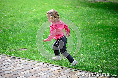 Funny little girl runing on green grass Stock Photo