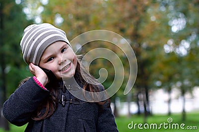 Funny little girl talking to a cell phone Stock Photo