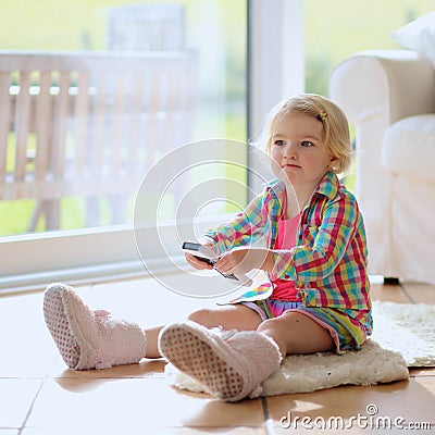 Funny little girl watching tv at home Stock Photo