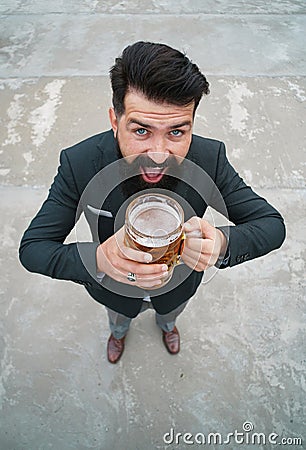 Funny man in classical suit holding glass with beer in hand. Smiling man with beer. Bartender, happy brewer. Full length Stock Photo