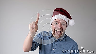 Funny Man in a New Year's Hat Counts Fingers, like Shows Numbers Stock Photo