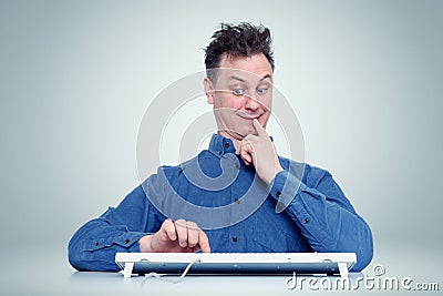 Funny man thinks click on the enter button or not. Indecisive programmer Stock Photo