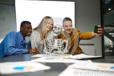 Funny managers, selfie with skeleton in IT office Stock Photo