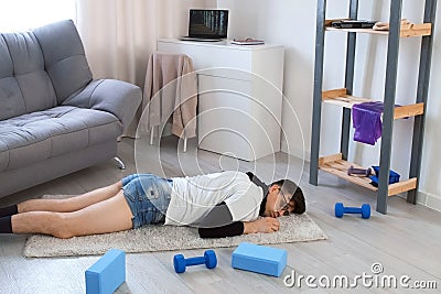 Funny nerd man in glasses is falling on carpet and sleeping on floor at home. Stock Photo