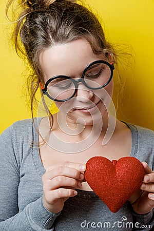 Funny nerdy woman with a red heart on a yellow background. Valen Stock Photo