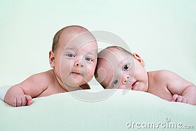 Funny newborn baby twins lying on stomach Stock Photo