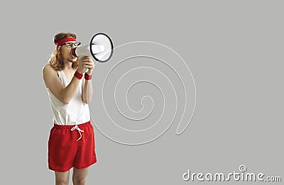 Funny man in sportswear yelling in megaphone standing isolated on grey background Stock Photo