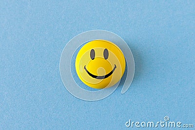Funny plastic smiley face on a blue background. The concept of a positive mood Editorial Stock Photo