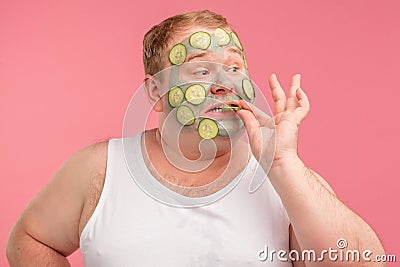 Funny plump middle-aged man applies a mask of clay to cleanse the skin Stock Photo