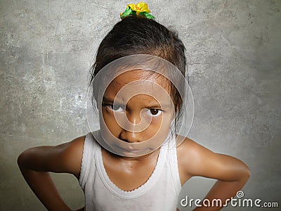 Funny portrait of sweet angry and mad 8 or 9 years old child looking upset to the camera feeling and unhappy isolated on Stock Photo