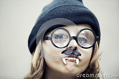 Funny portrait of young boy with big glasses, fake teeth and mus Stock Photo