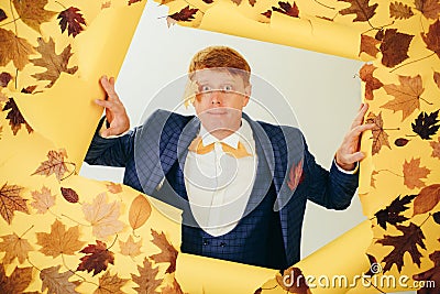 Funny read head man with background board for Copyspace. Surprise read head man playing with leaves and looking at Stock Photo